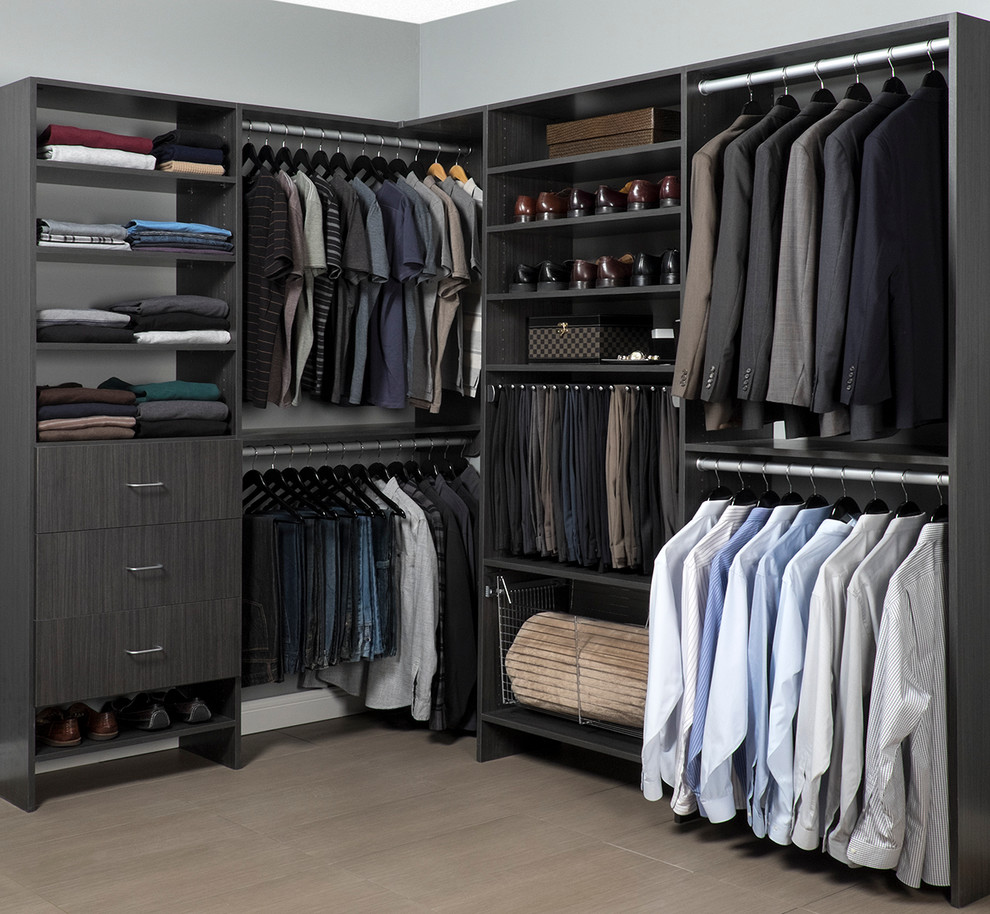 Ejemplo de armario vestidor unisex actual de tamaño medio con armarios con paneles lisos, puertas de armario grises y suelo de madera clara