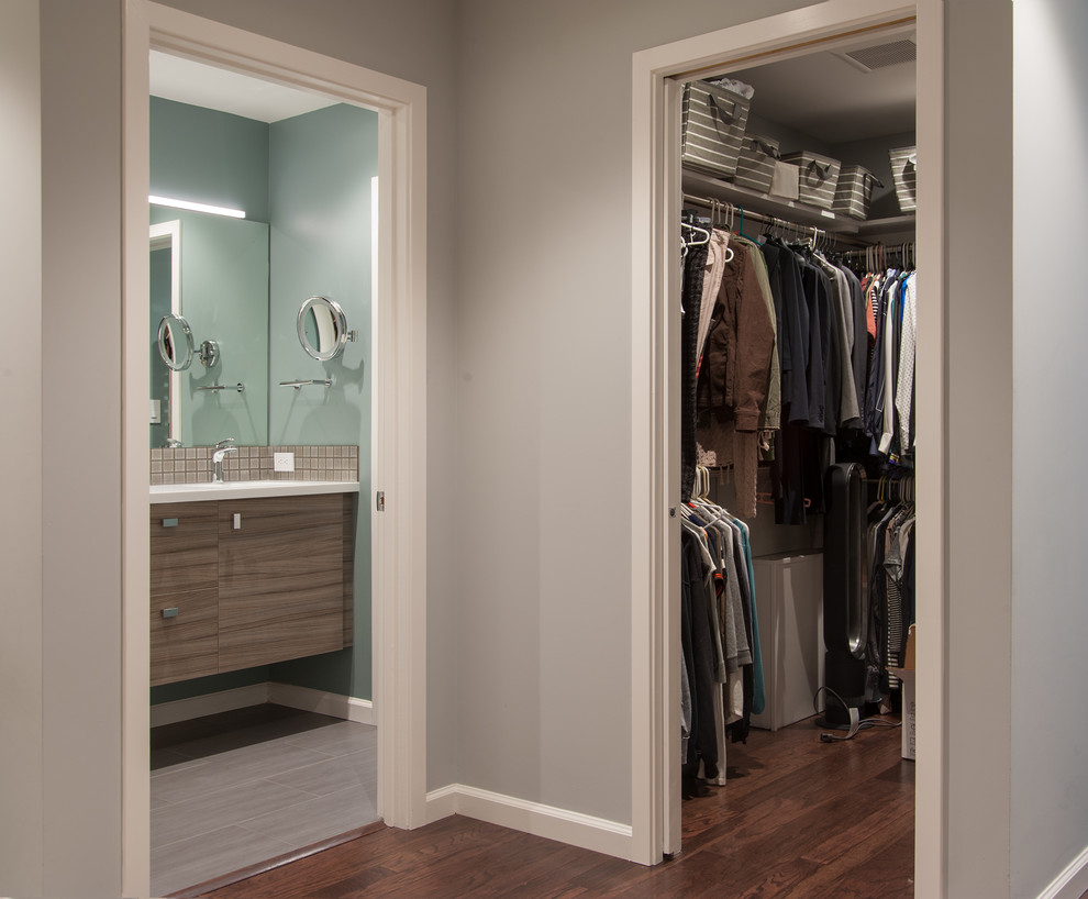 Foto de armario vestidor de mujer moderno pequeño con armarios abiertos, puertas de armario blancas y suelo de madera en tonos medios