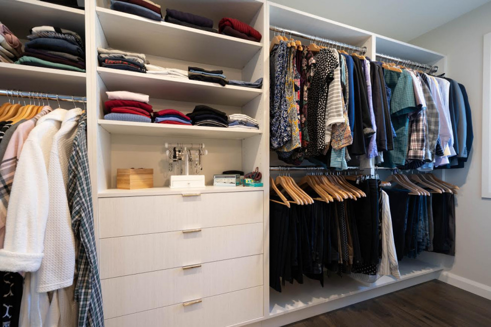 Imagen de armario vestidor vintage grande con armarios con paneles lisos, puertas de armario de madera clara, suelo de madera oscura y suelo marrón