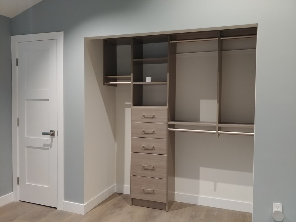 Ejemplo de armario de hombre minimalista pequeño con armarios con paneles lisos