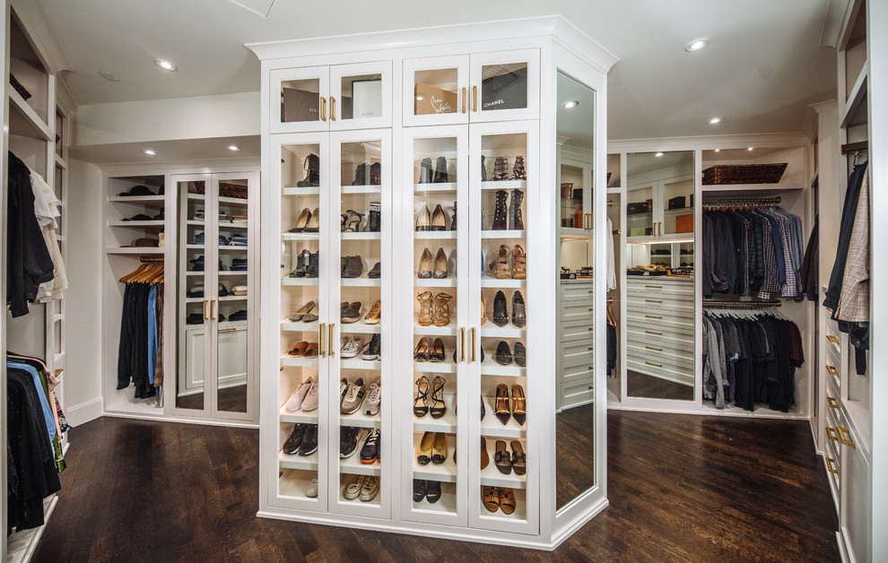 Large traditional gender neutral walk-in wardrobe in Dallas with beaded cabinets, white cabinets, dark hardwood flooring and brown floors.