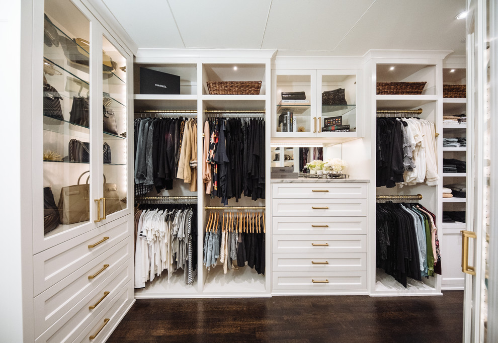 Ejemplo de armario vestidor unisex clásico renovado grande con armarios con rebordes decorativos, puertas de armario blancas y suelo de madera oscura