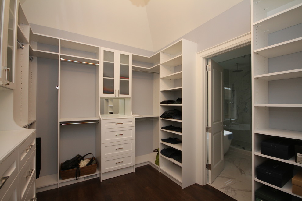 Modelo de vestidor unisex clásico renovado grande con armarios estilo shaker, puertas de armario blancas y suelo de madera oscura