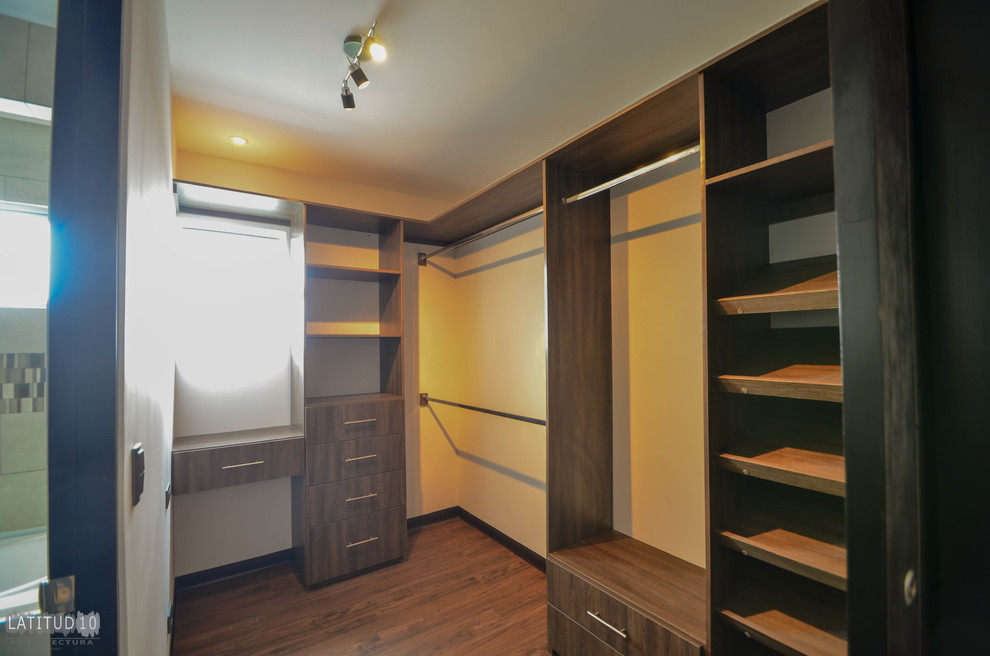 Foto di una piccola cabina armadio unisex contemporanea con ante lisce, ante in legno bruno e pavimento in vinile