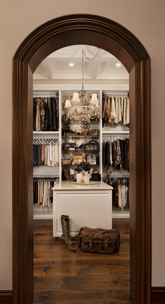 Idée de décoration pour un dressing tradition pour une femme avec un placard sans porte, des portes de placard blanches et parquet foncé.