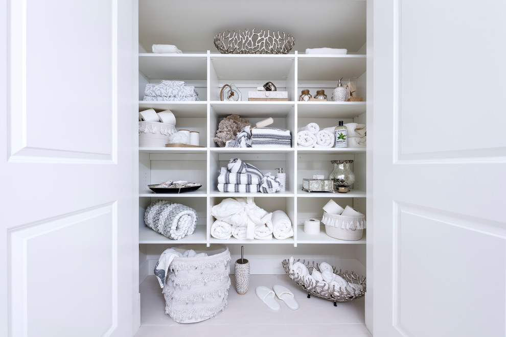 Ejemplo de armario unisex pequeño con puertas de armario blancas, suelo de baldosas de porcelana y suelo blanco