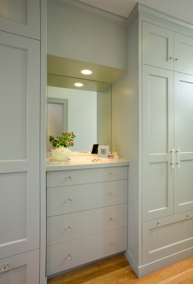 Medium sized traditional dressing room in San Francisco with recessed-panel cabinets, white cabinets and medium hardwood flooring.