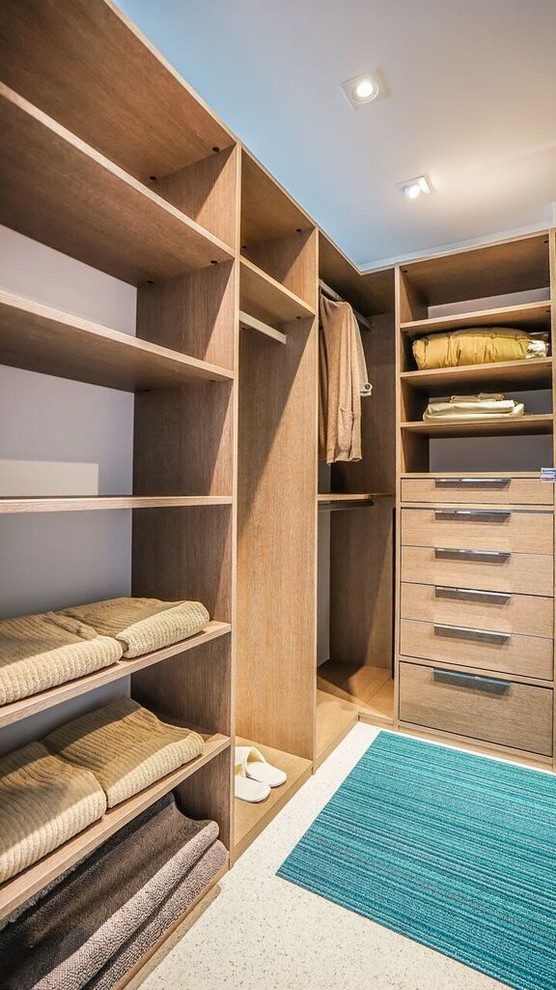 Inspiration for a large contemporary gender-neutral walk-in wardrobe in Miami with flat-panel cabinets, medium wood cabinets and concrete floors.