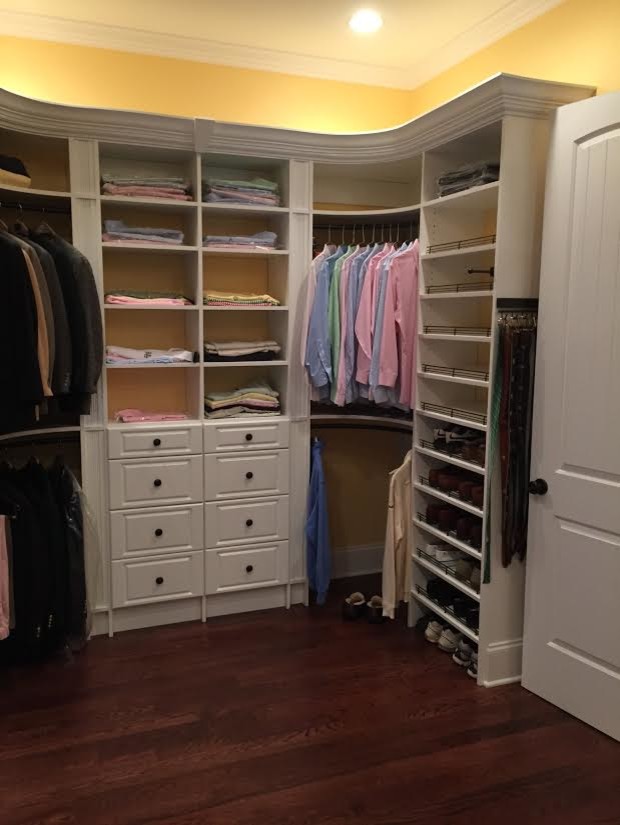 Ejemplo de armario vestidor unisex clásico de tamaño medio con armarios con paneles con relieve, puertas de armario blancas, suelo de madera oscura y suelo marrón