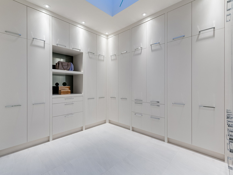 Cette image montre un dressing room design neutre avec un placard à porte plane, des portes de placard blanches et un sol blanc.