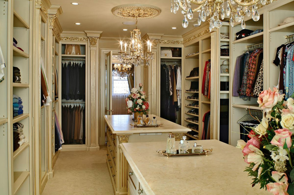 Diseño de vestidor unisex tradicional de tamaño medio con armarios abiertos, suelo de baldosas de porcelana, suelo beige y puertas de armario beige