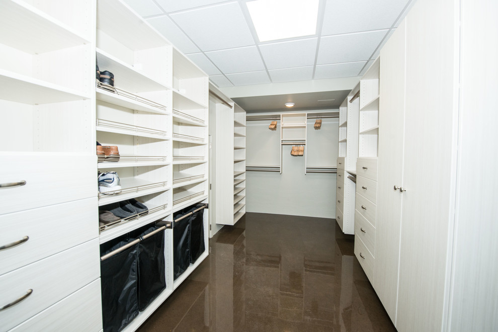 Ejemplo de armario vestidor unisex minimalista grande con armarios con paneles lisos, puertas de armario blancas y suelo de madera en tonos medios