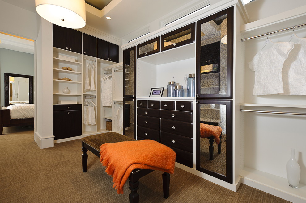 На фото: гардеробная комната в современном стиле с темными деревянными фасадами