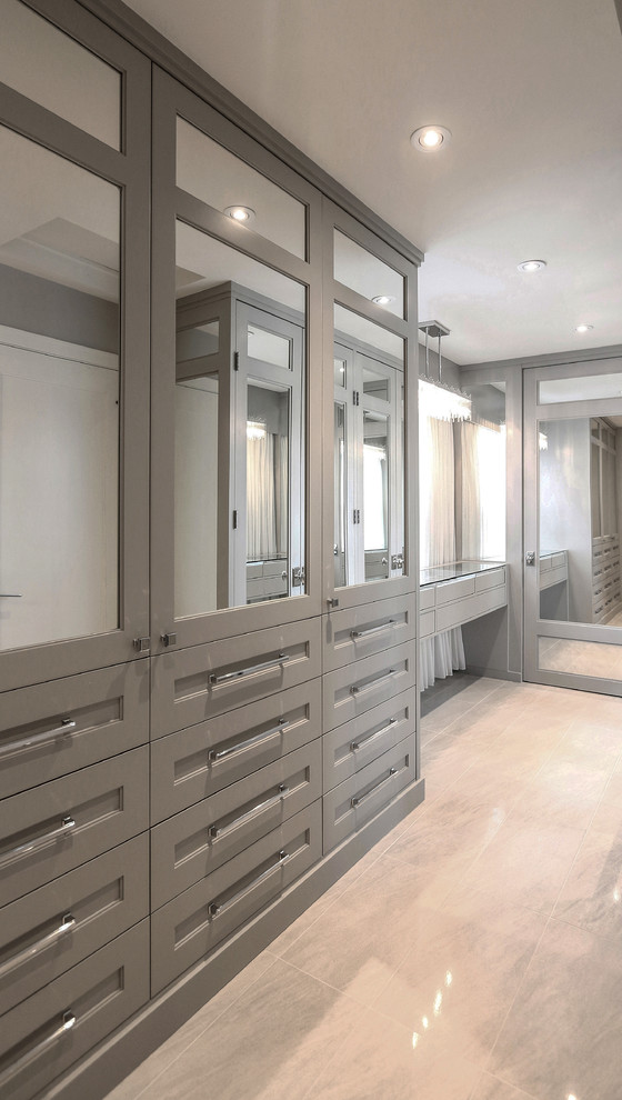 Cette image montre un grand dressing room design neutre avec un placard à porte shaker, des portes de placard grises et un sol en marbre.