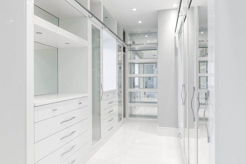 Large minimalist women's walk-in closet photo in Miami with flat-panel cabinets and white cabinets