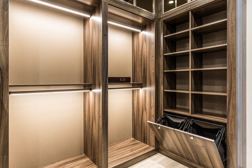 This is an example of a large modern walk-in wardrobe for men in Miami with flat-panel cabinets.