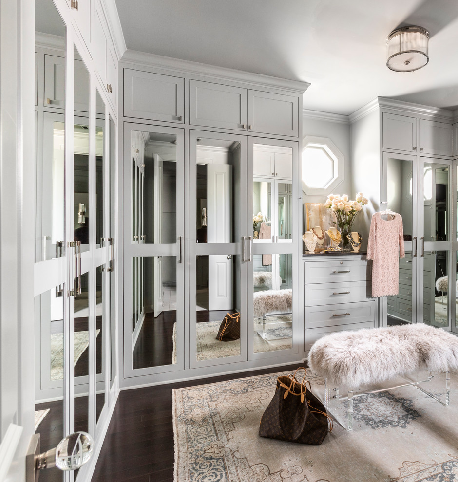 Réalisation d'un dressing tradition pour une femme avec un placard à porte shaker, des portes de placards vertess, parquet foncé et un sol marron.