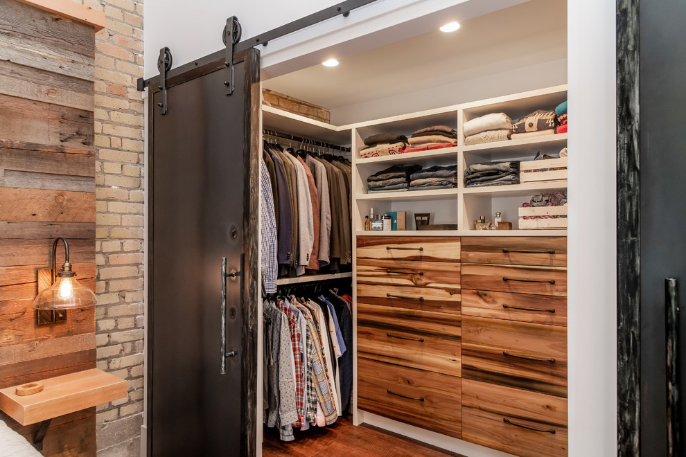 Modelo de armario vestidor unisex urbano con armarios con paneles lisos, puertas de armario de madera oscura, suelo laminado y suelo marrón