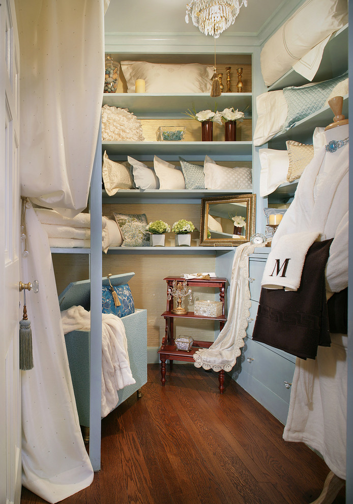 Diseño de armario vestidor unisex romántico de tamaño medio con armarios con paneles lisos, puertas de armario azules y suelo de madera en tonos medios