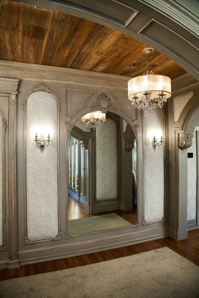 Идея дизайна: большая гардеробная комната в средиземноморском стиле с фасадами с выступающей филенкой, серыми фасадами, темным паркетным полом и коричневым полом для женщин