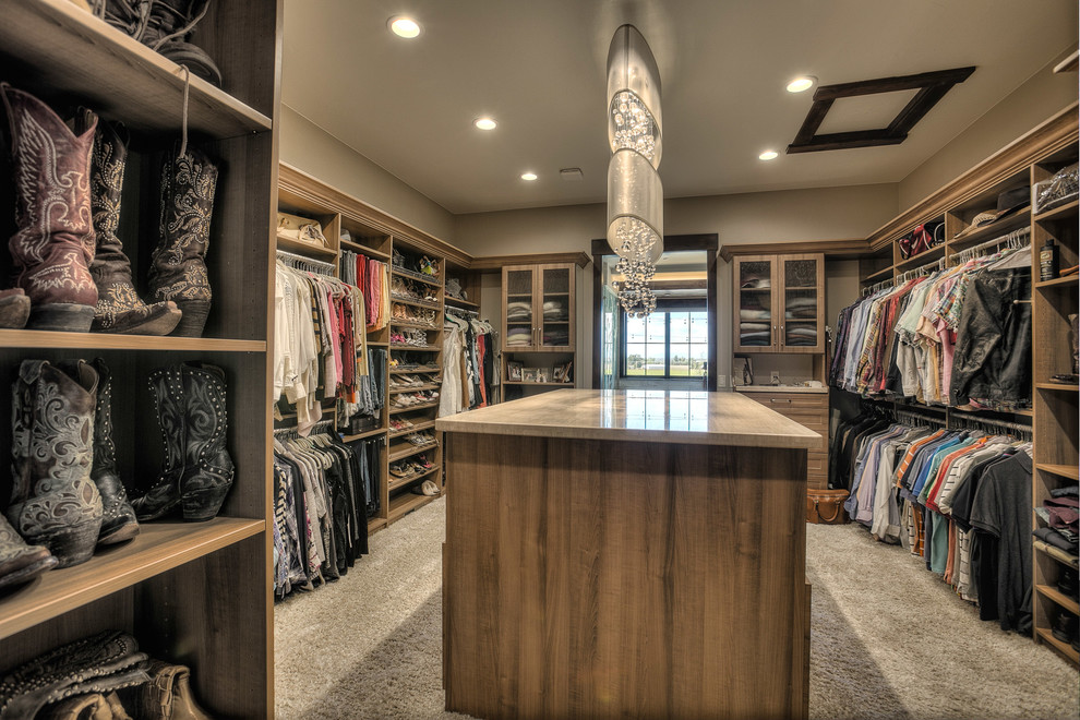 Inspiration for an expansive rustic gender neutral walk-in wardrobe in Denver with shaker cabinets, medium wood cabinets and carpet.