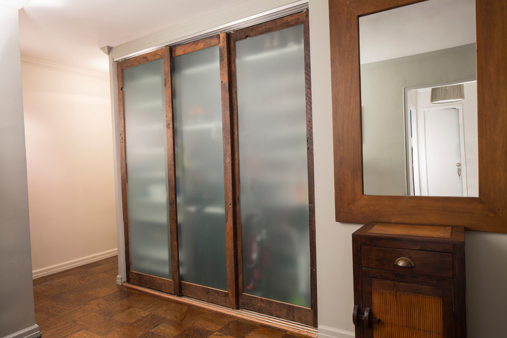 Modelo de armario de hombre campestre pequeño con armarios con paneles lisos, puertas de armario con efecto envejecido y suelo de madera en tonos medios