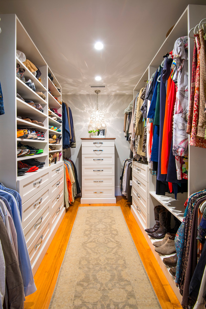 Modelo de armario vestidor unisex tradicional renovado de tamaño medio con armarios estilo shaker, puertas de armario blancas, suelo de madera clara y suelo marrón