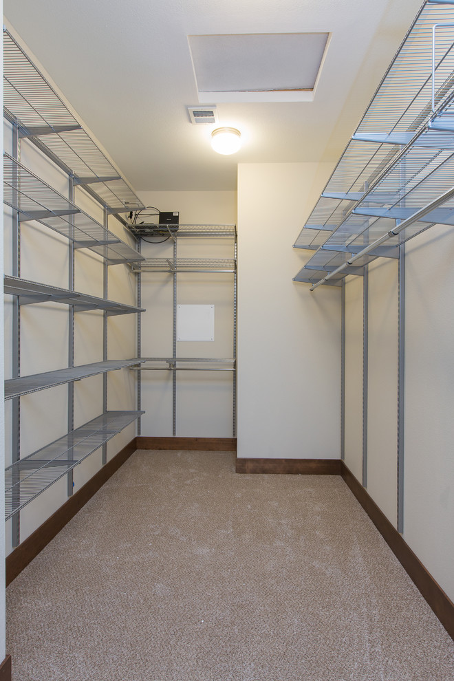 Photo of a large modern gender neutral walk-in wardrobe in Portland with carpet and open cabinets.