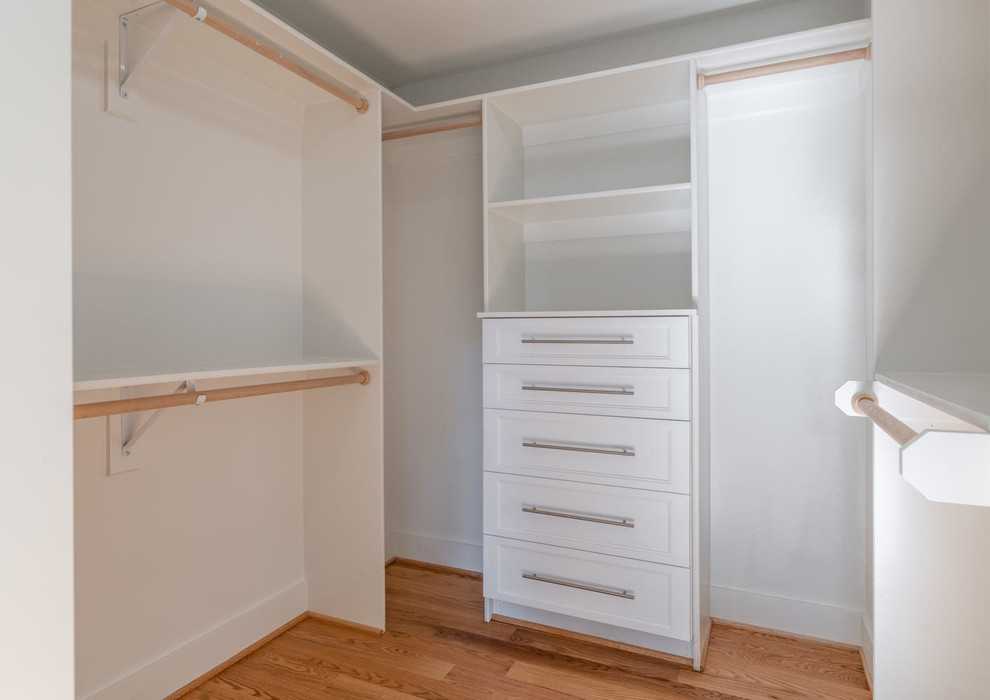 Foto de armario vestidor unisex de tamaño medio con armarios estilo shaker, puertas de armario blancas, suelo de madera en tonos medios y suelo marrón
