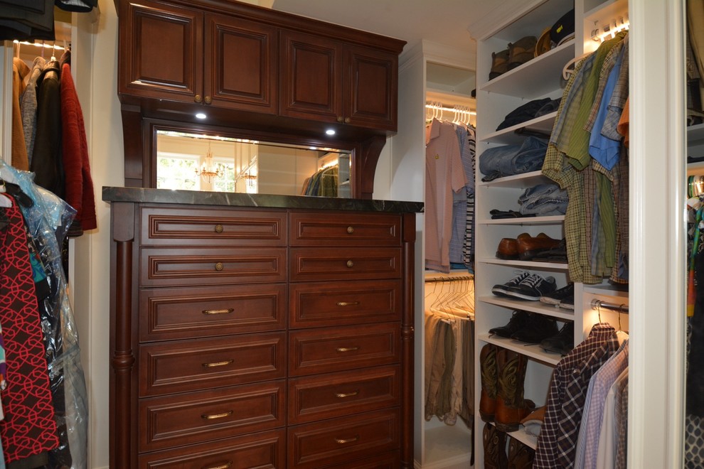 Design ideas for a medium sized traditional gender neutral walk-in wardrobe in Tampa with recessed-panel cabinets and medium wood cabinets.