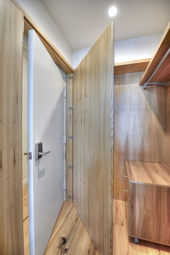 Modernes Ankleidezimmer mit hellbraunen Holzschränken und braunem Holzboden in Miami