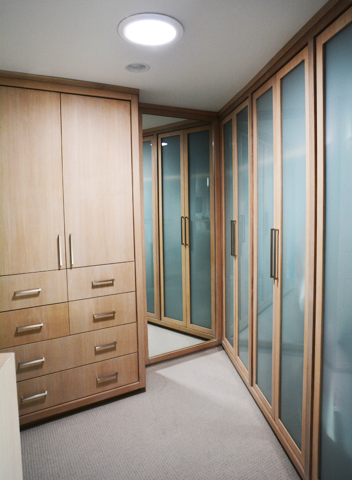 Exemple d'un dressing room tendance en bois clair de taille moyenne et neutre avec un placard à porte plane et moquette.