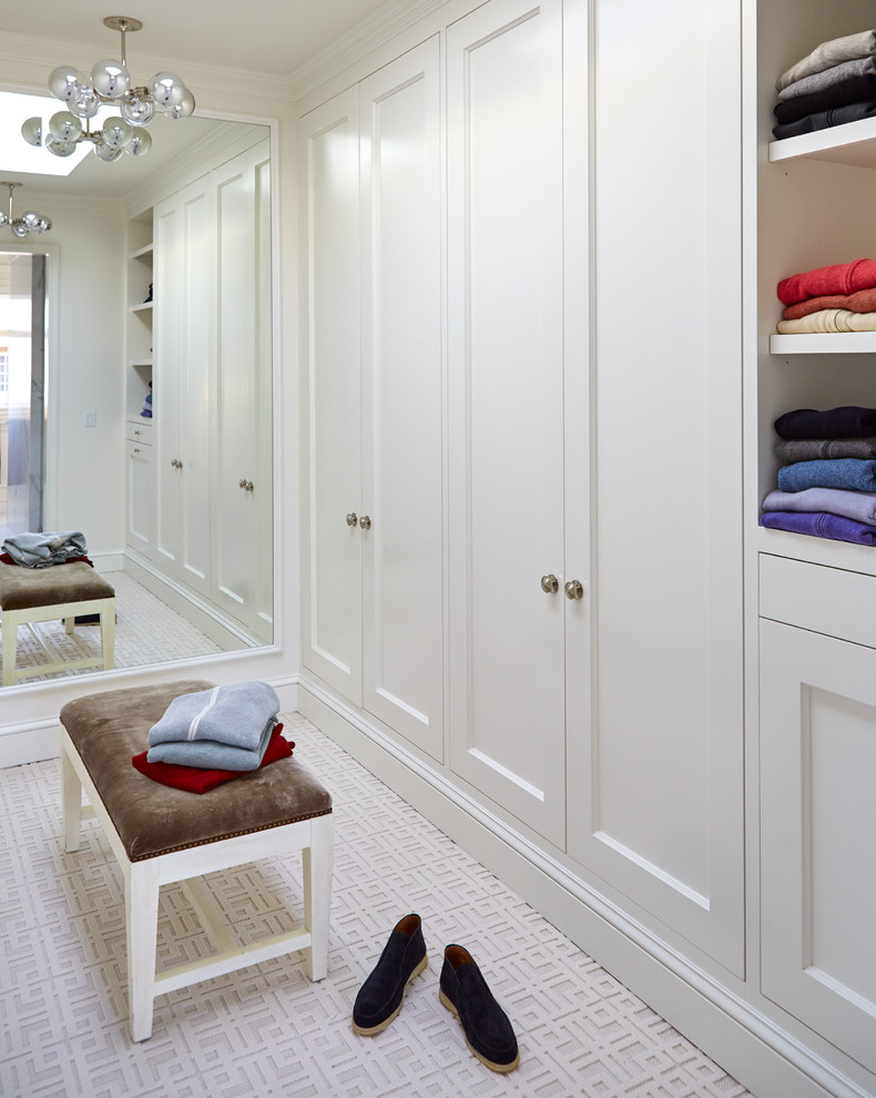Источник вдохновения для домашнего уюта: большая гардеробная комната унисекс в стиле неоклассика (современная классика) с фасадами с утопленной филенкой, белыми фасадами и ковровым покрытием