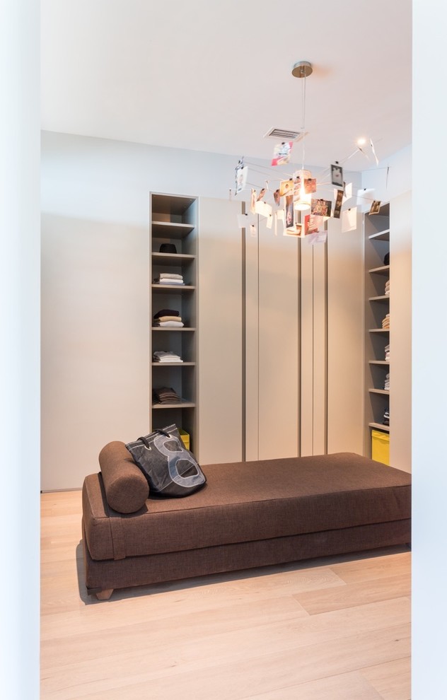 Diseño de vestidor unisex minimalista grande con armarios abiertos, puertas de armario de madera clara y suelo de bambú
