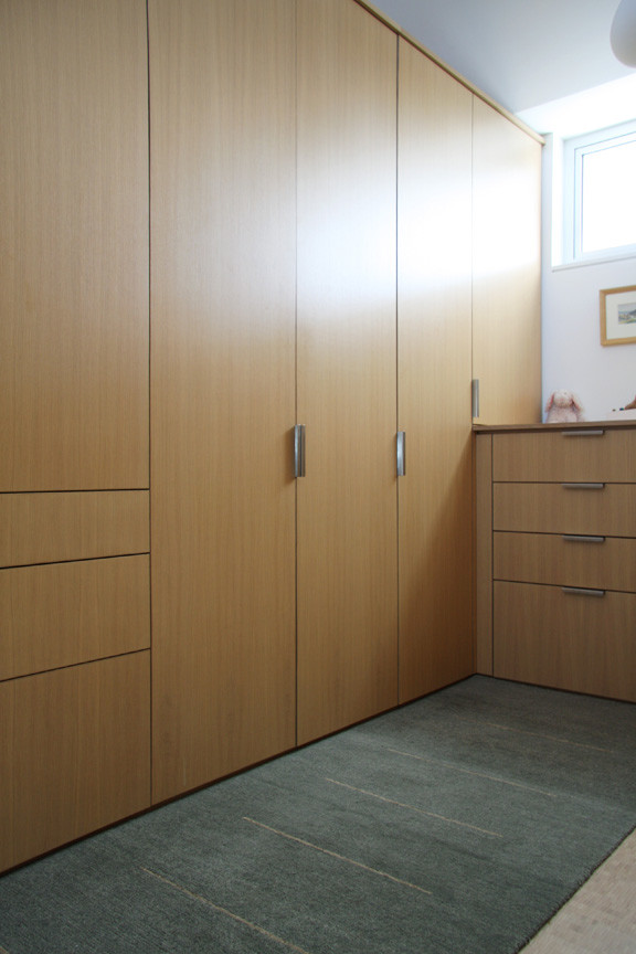 Large minimalist gender-neutral walk-in closet photo in San Francisco with flat-panel cabinets and medium tone wood cabinets