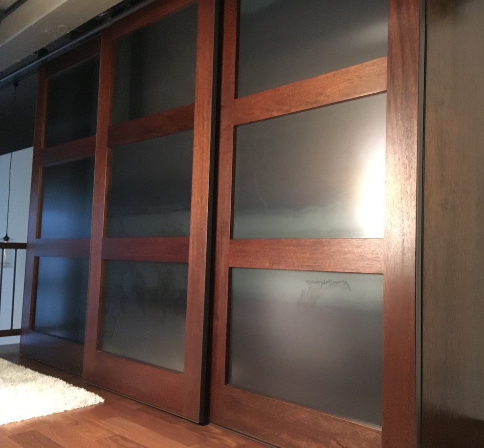 Reach-in closet - large industrial medium tone wood floor reach-in closet idea in Seattle with medium tone wood cabinets