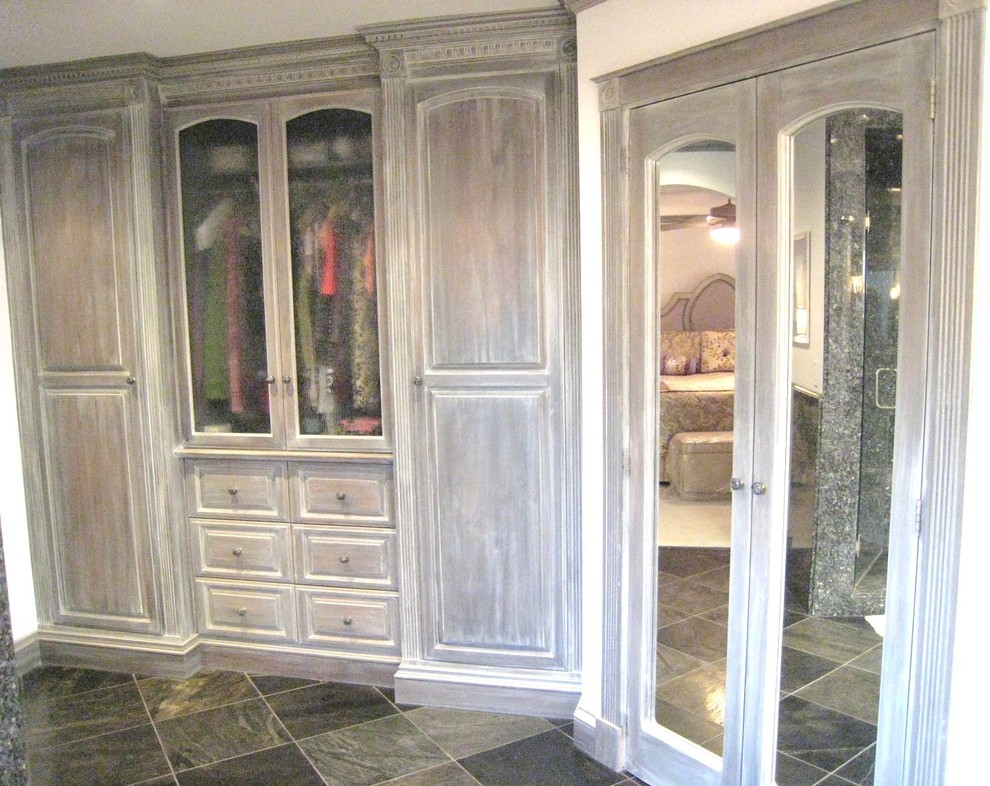 На фото: большая гардеробная комната унисекс в классическом стиле с фасадами с выступающей филенкой, искусственно-состаренными фасадами и полом из сланца