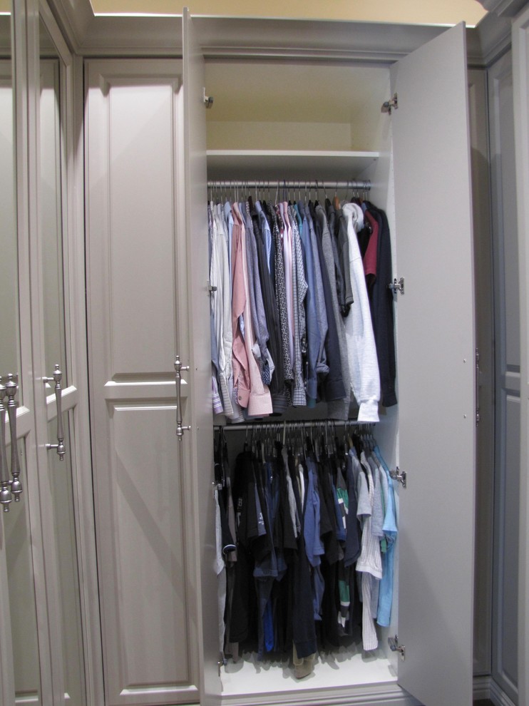 Large classic walk-in wardrobe for men in San Francisco with raised-panel cabinets, grey cabinets, dark hardwood flooring and brown floors.
