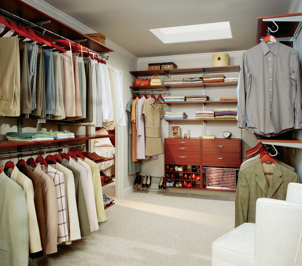 Modelo de armario vestidor unisex clásico de tamaño medio con armarios con paneles lisos, puertas de armario de madera en tonos medios y moqueta
