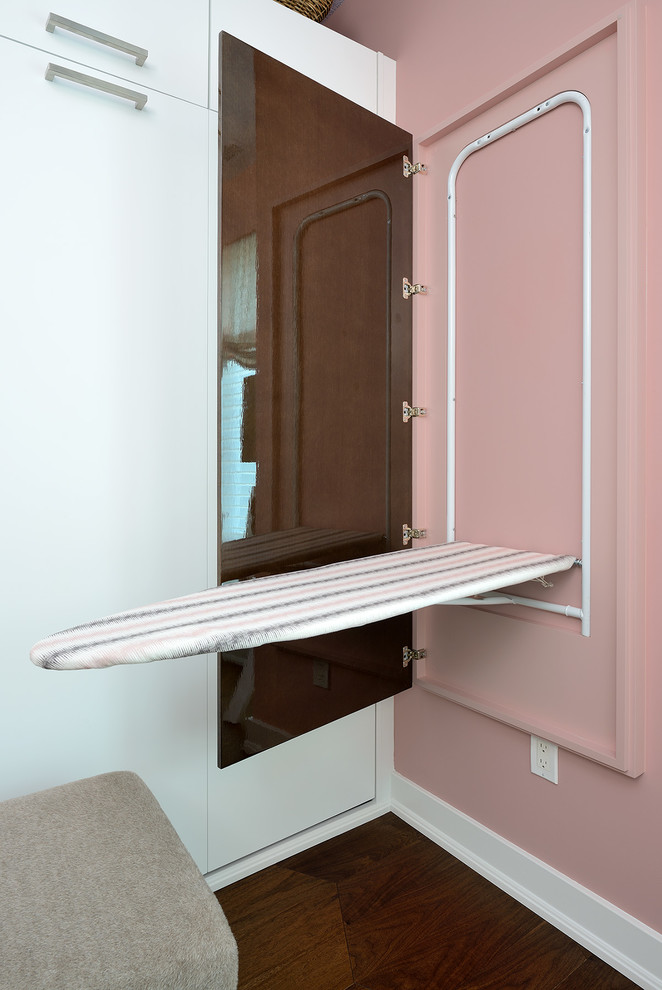 Cette image montre un grand dressing room minimaliste pour une femme avec un placard à porte plane, des portes de placard blanches et parquet foncé.