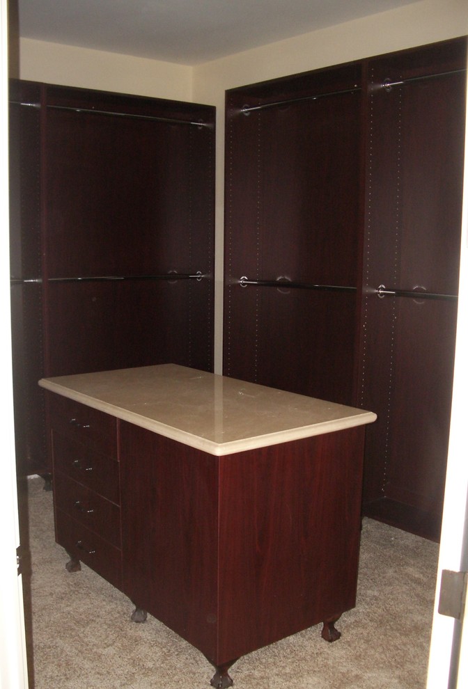 Inredning av ett medelhavsstil litet walk-in-closet för könsneutrala, med öppna hyllor, skåp i mörkt trä, kalkstensgolv och flerfärgat golv