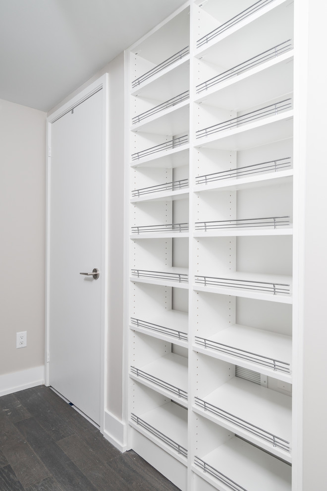 Modelo de armario unisex minimalista pequeño con armarios abiertos, puertas de armario blancas y suelo de madera en tonos medios