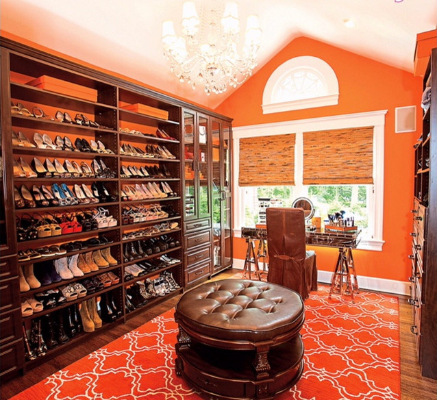 Example of a large eclectic women's medium tone wood floor and brown floor dressing room design in Orange County with glass-front cabinets and medium tone wood cabinets