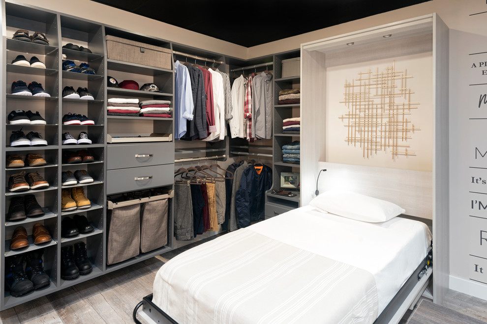Diseño de armario vestidor unisex actual grande con armarios con paneles lisos, puertas de armario de madera clara, suelo de baldosas de porcelana y suelo beige