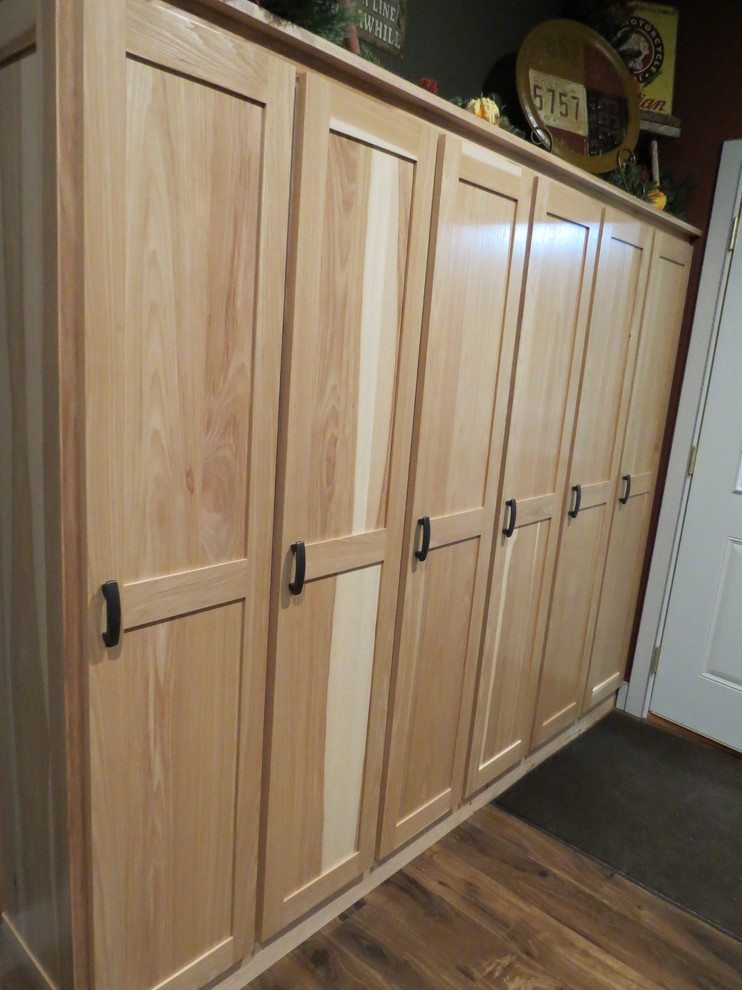 Cette photo montre un placard dressing chic en bois clair de taille moyenne et neutre avec un placard à porte shaker et un sol en bois brun.