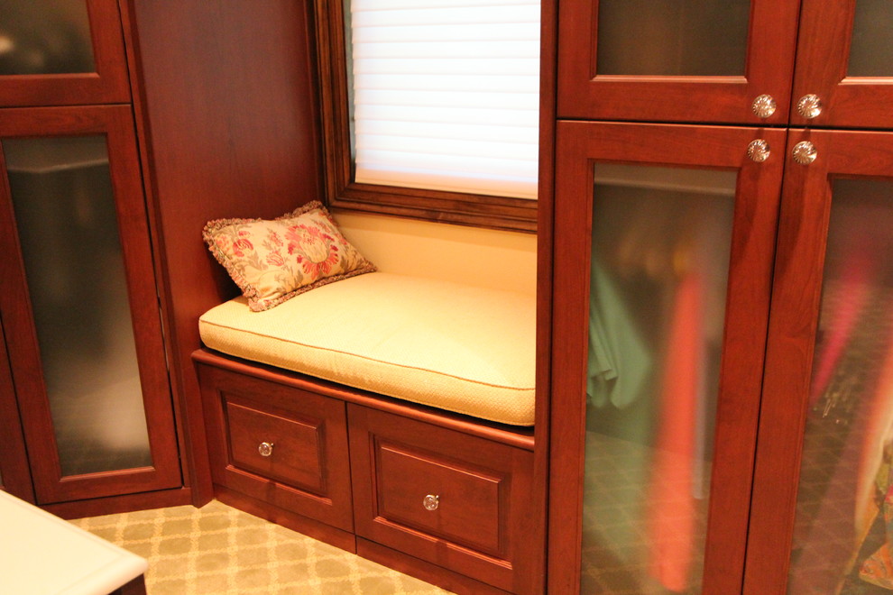 Foto de armario vestidor unisex clásico grande con armarios con paneles empotrados, puertas de armario de madera en tonos medios, moqueta y suelo beige