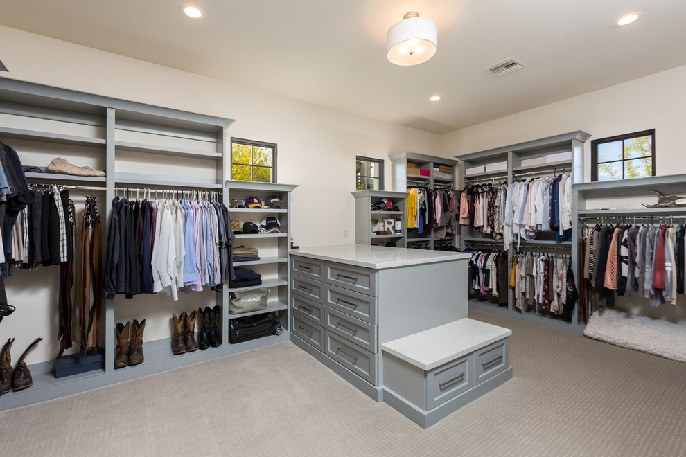 Imagen de vestidor unisex contemporáneo extra grande con armarios abiertos, puertas de armario grises, moqueta y suelo beige