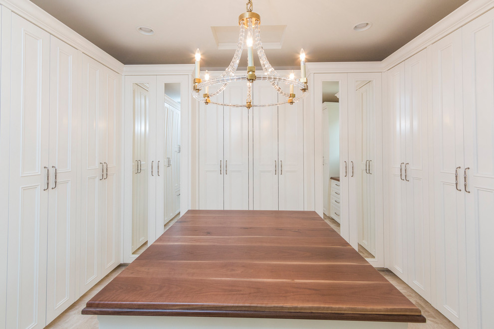 Photo of an expansive classic gender neutral walk-in wardrobe in Phoenix with raised-panel cabinets, white cabinets, marble flooring and beige floors.