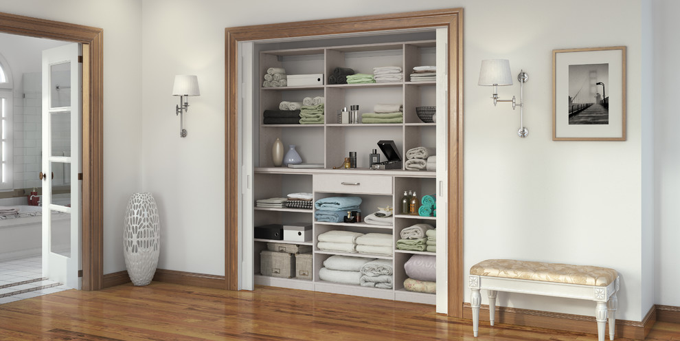 Foto de armario unisex actual pequeño con armarios abiertos, puertas de armario blancas y suelo de madera en tonos medios