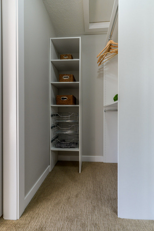 Bild på ett litet funkis walk-in-closet för könsneutrala, med vita skåp och heltäckningsmatta